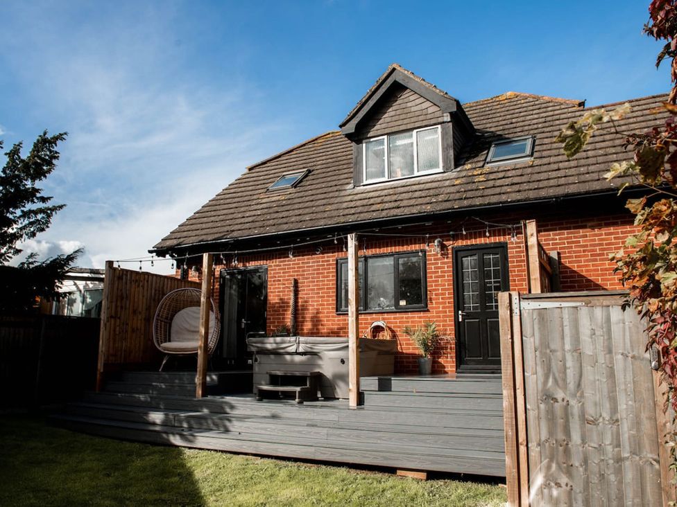 A house with a deck and spa in the backyard at the property