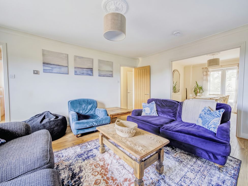 A living room with a blue armchair and a purple sofa at the property in location