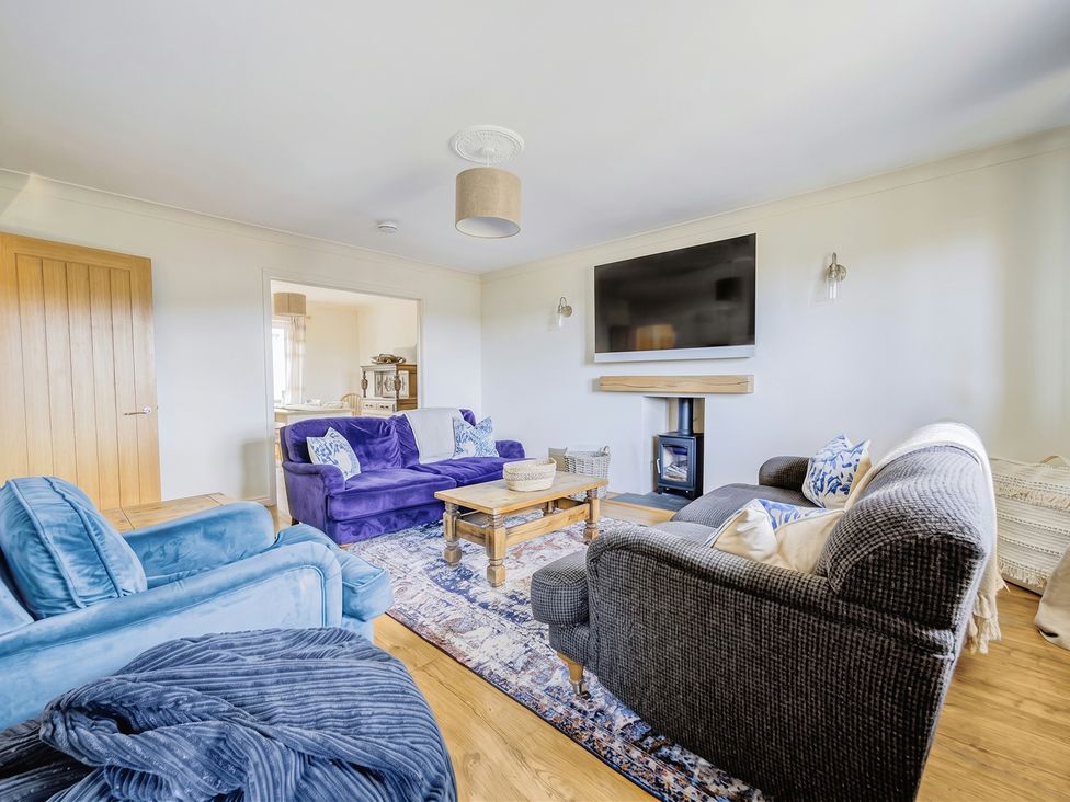 A living room with a TV, sofas, and a coffee table at The Old Barn in Manchester