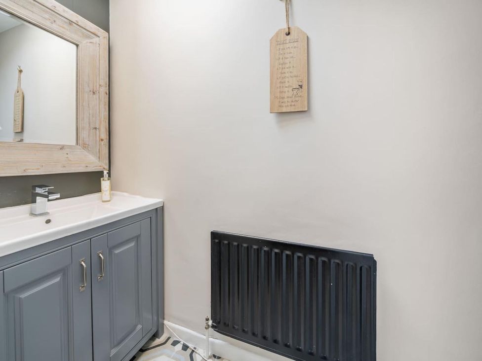 A bathroom with a sink and vanity under a mirror at 