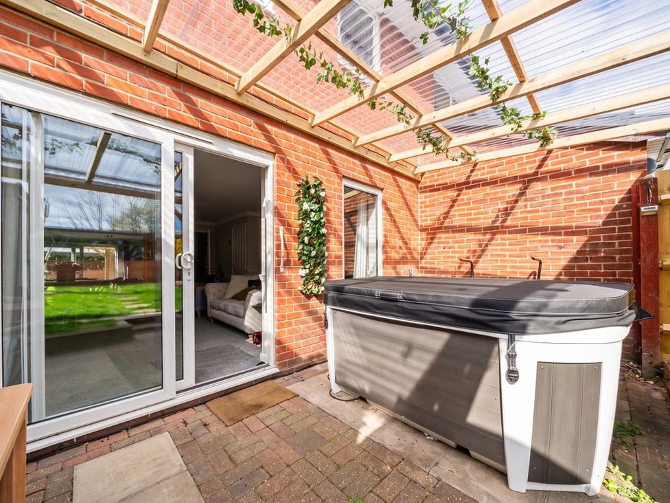 A conservatory featuring a hot tub and sliding glass door at The Old Barn in Manchester
