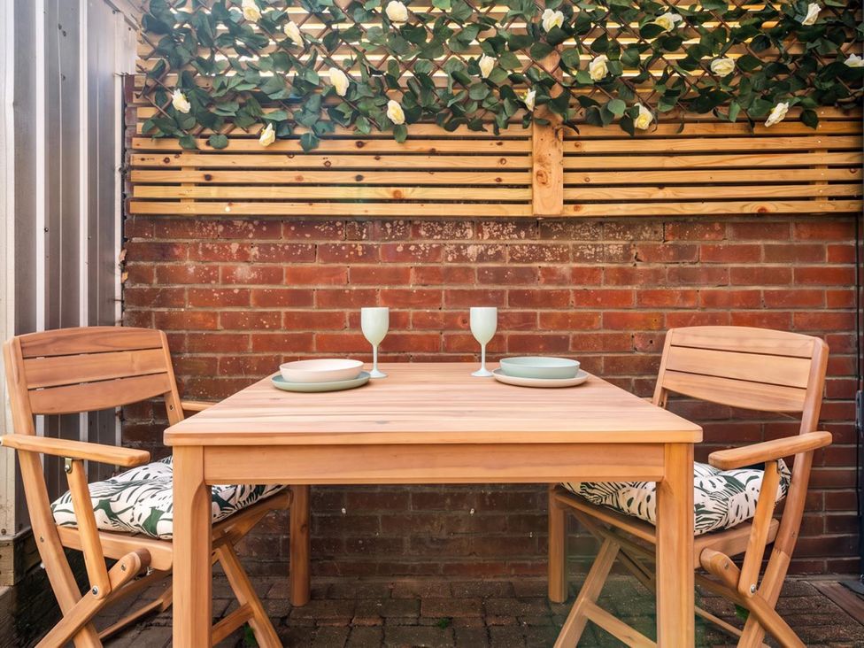 A table with chairs and dinnerware in an outdoor dining area at the property located in 