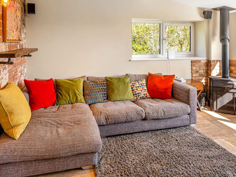 A living room with a sofa and wood stove