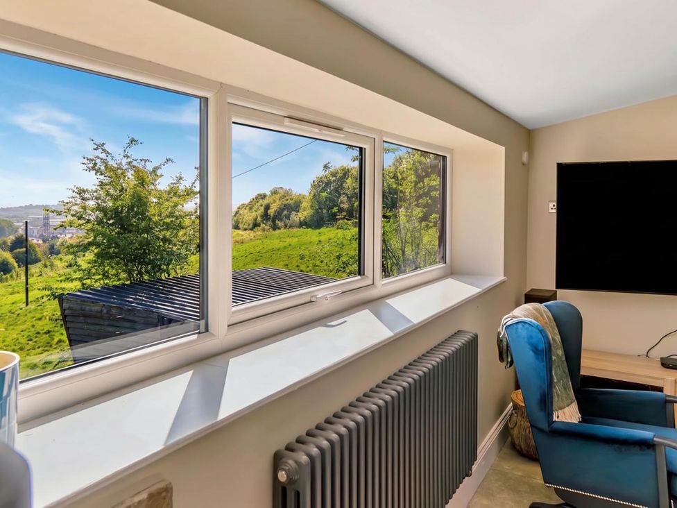 An office with a view of greenery through windows at The Old Barn in Manchester