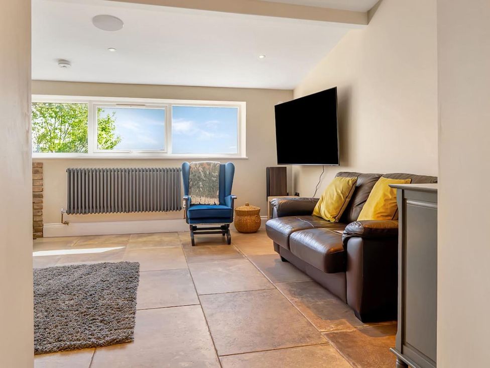 A living room with a sofa, a chair, and a television area at the property