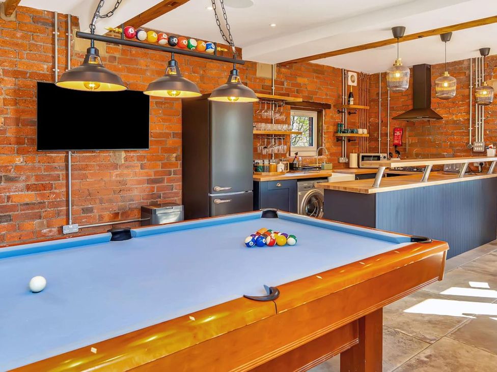 A game room with a pool table and kitchen appliances at The Old Barn in Manchester