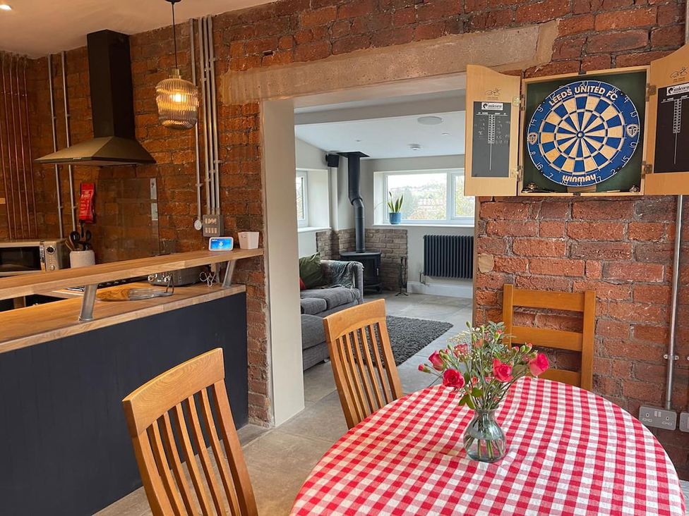 A kitchen with a dartboard and a dining table at The Old Barn in Manchester