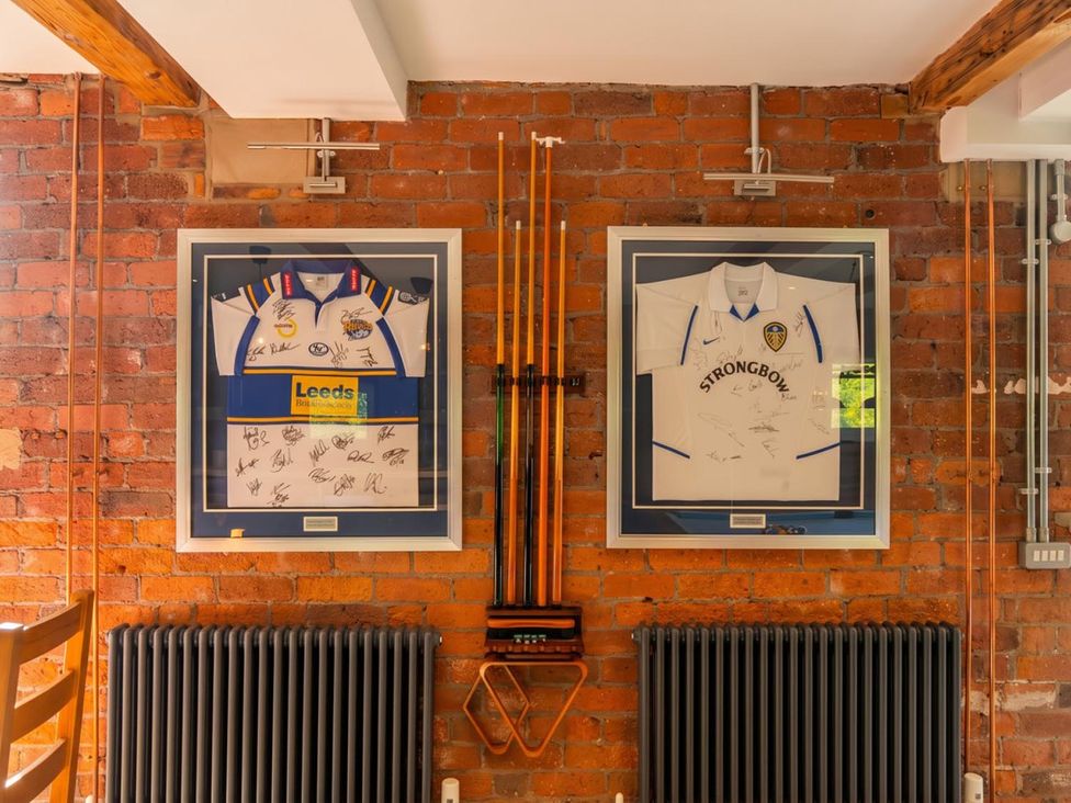 A game room with framed signed jerseys and a radiator at the property