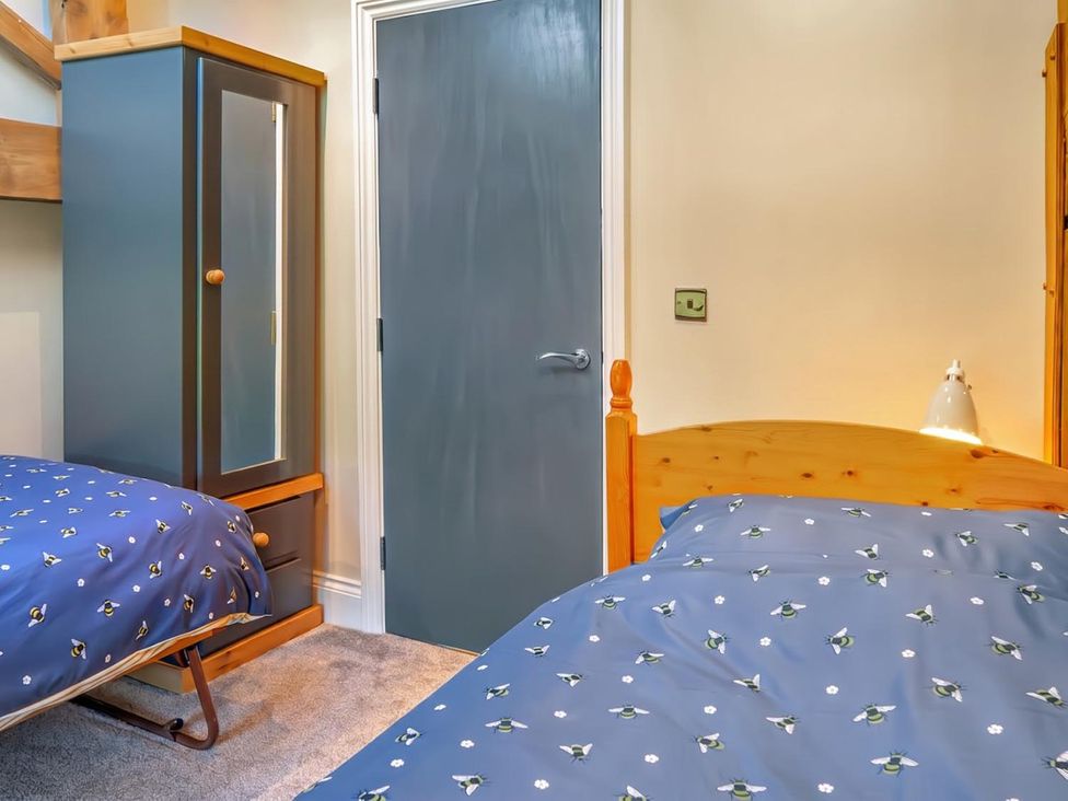 A bedroom with two beds and a wardrobe at The Old Barn in Manchester