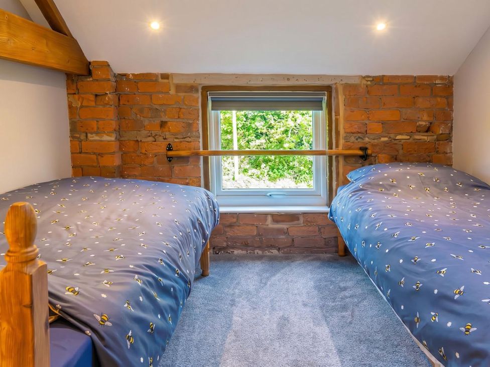 A bedroom with two beds and a window at The Old Barn in Manchester
