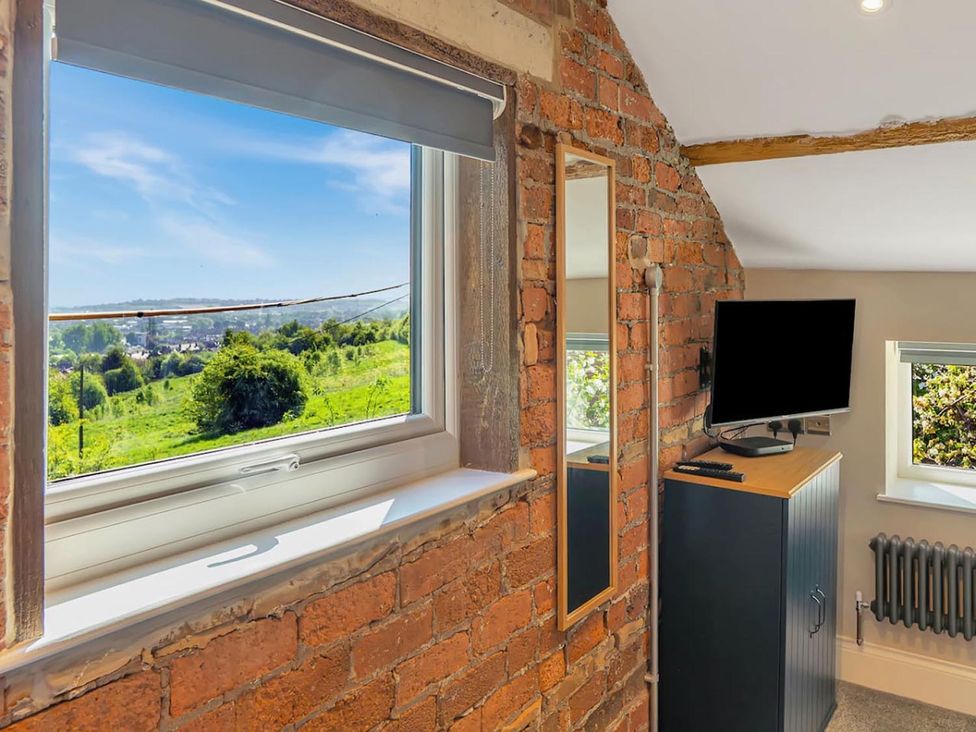 A bedroom with a window, mirror, and television at the property