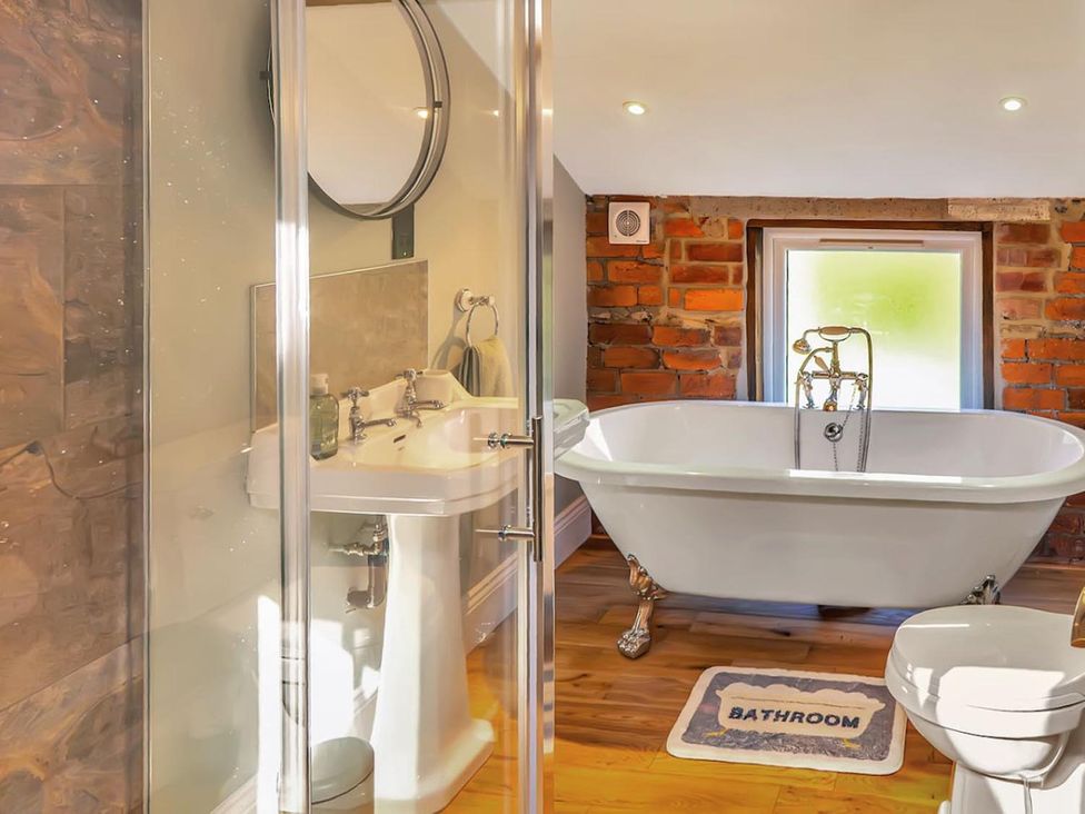 A bathroom with a bathtub and sink at The Old Barn in Manchester