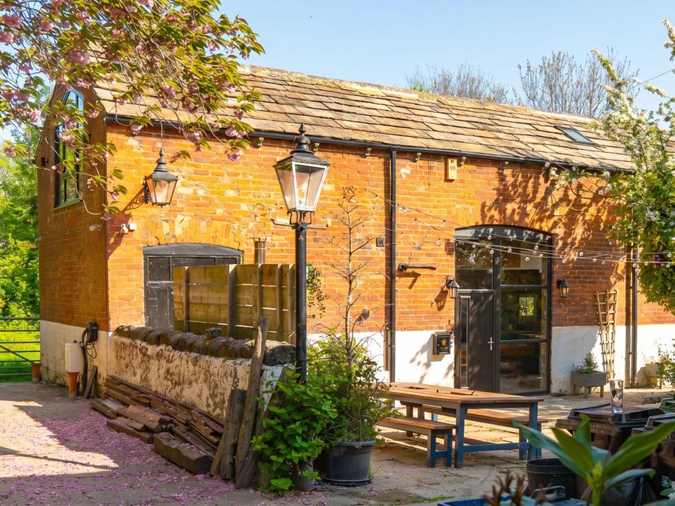 A brick exterior with outdoor seating at a property