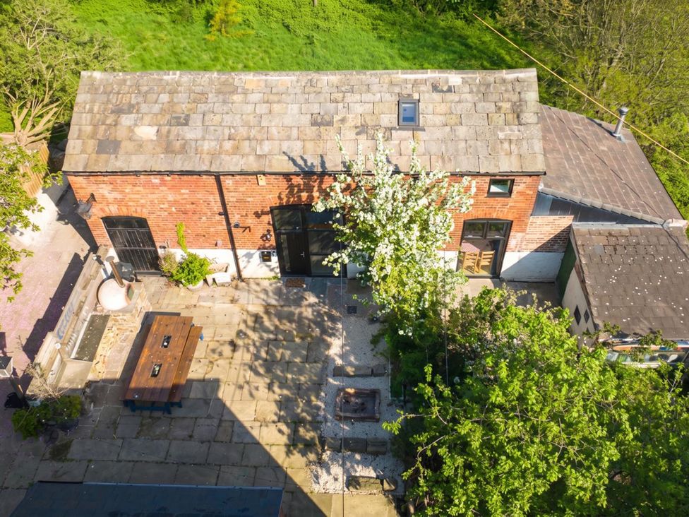 An outdoor area with a building, table, and trees at The Old Barn in Manchester