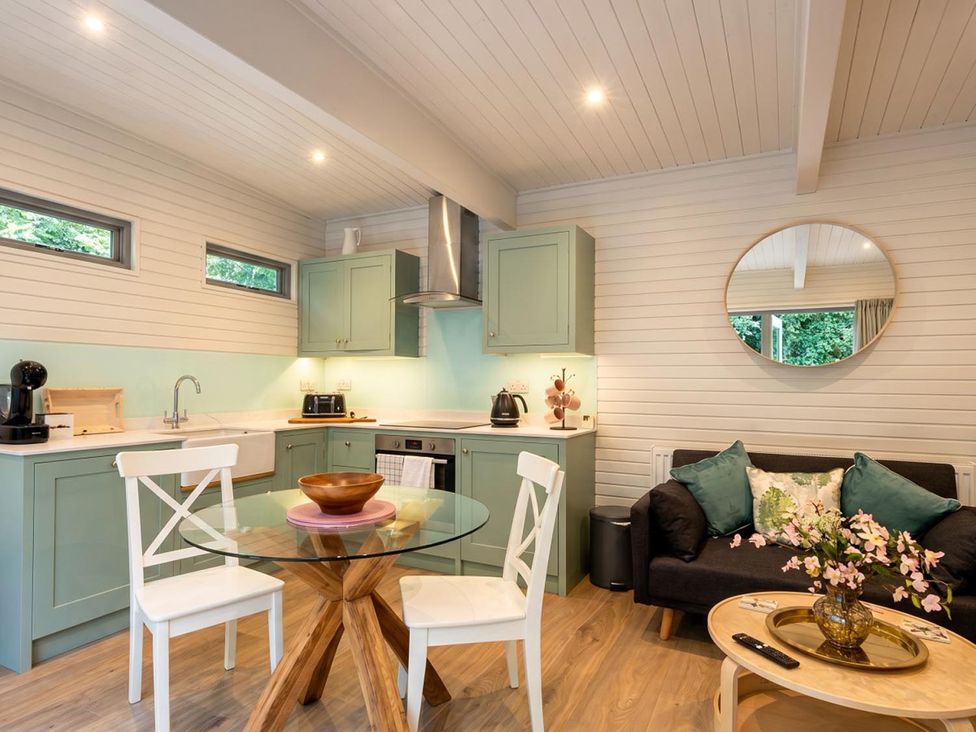 A kitchen with a table and chairs, sink, and appliances at the property in 