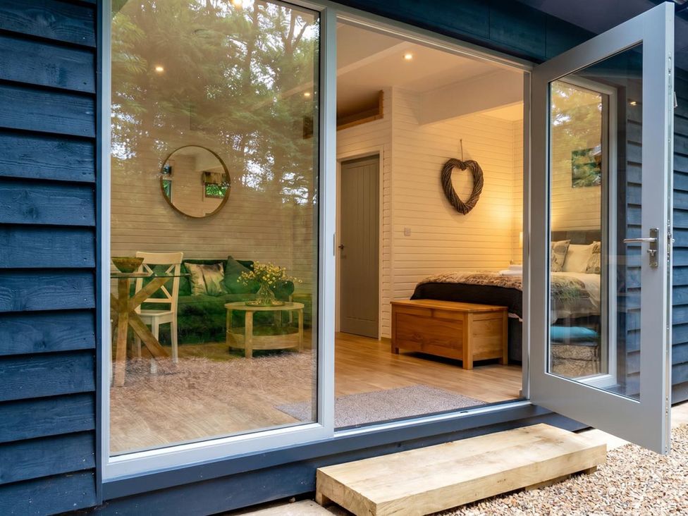 A living room with a couch and table visible through a glass door at the property in an unspecified location