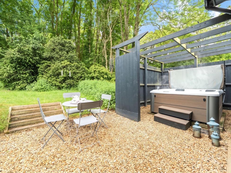 A garden with a hot tub and a seating area at a property