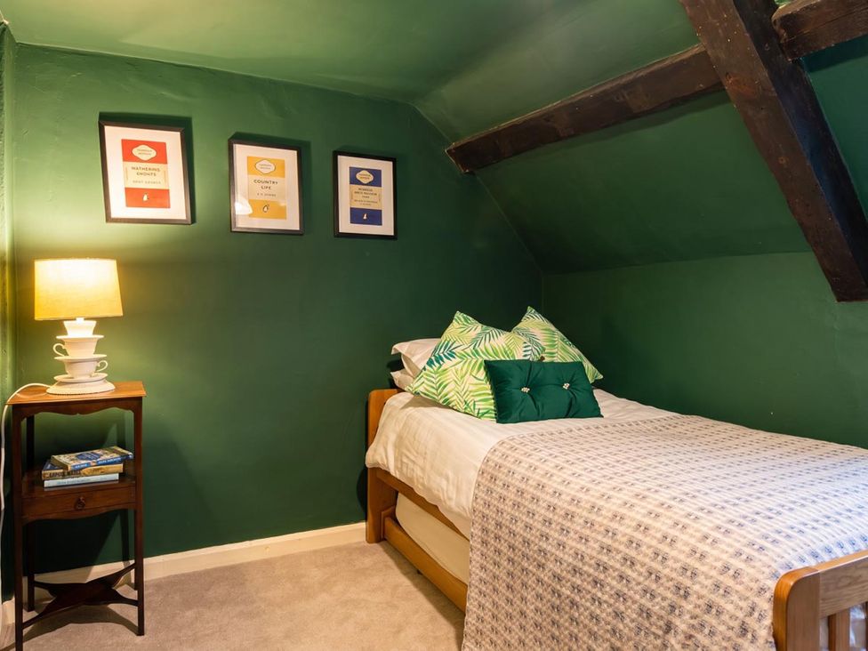 A bedroom with a bed and side table at  