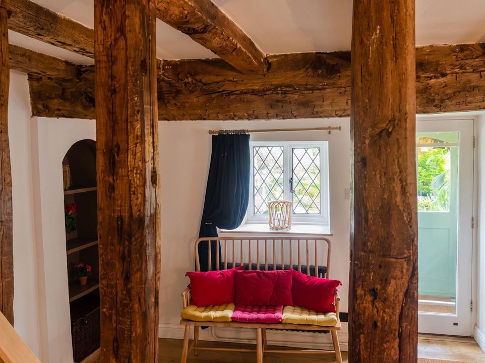 A living room with wooden beams and a sitting bench at the property
