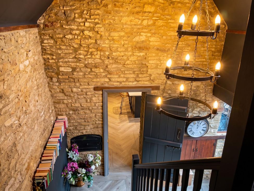 A hallway with a chandelier and books on a shelf at the property location