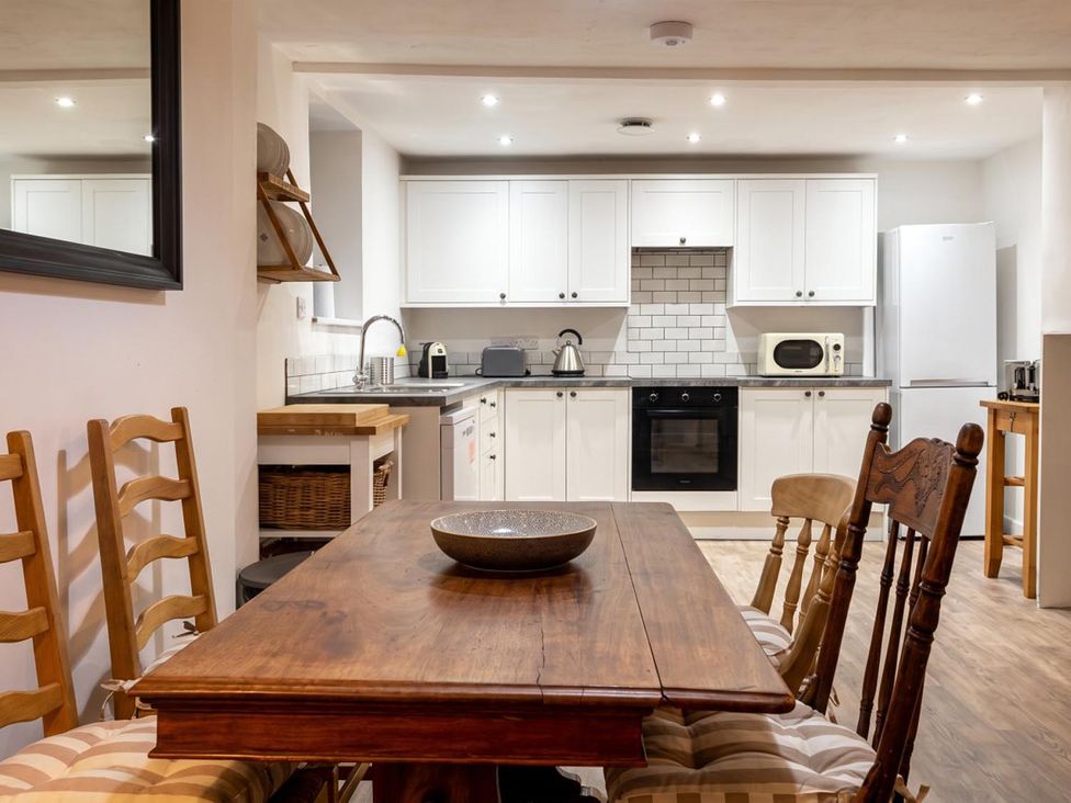 A kitchen with a wooden table and chairs at The Old Barn in Manchester