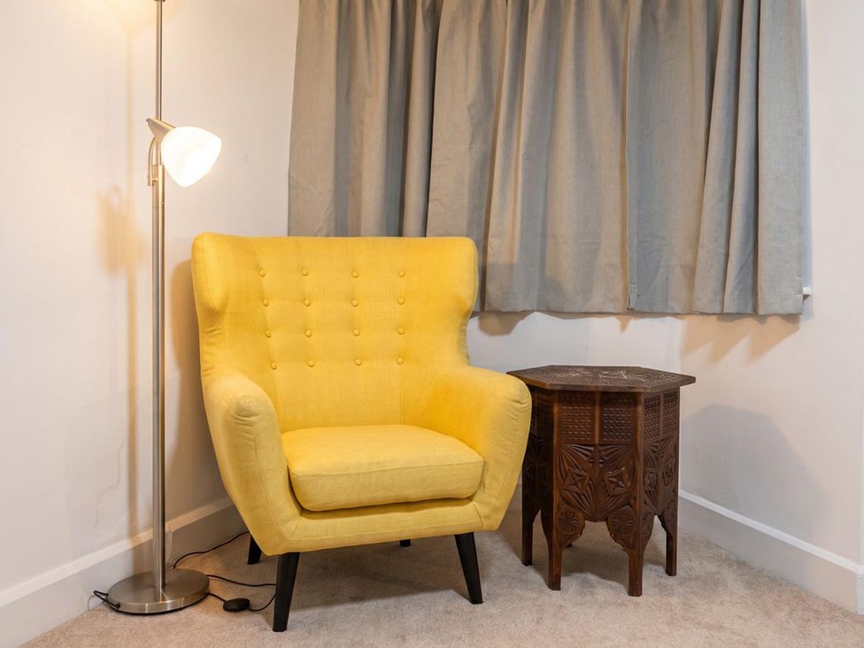 A living room with a yellow chair and side table at 