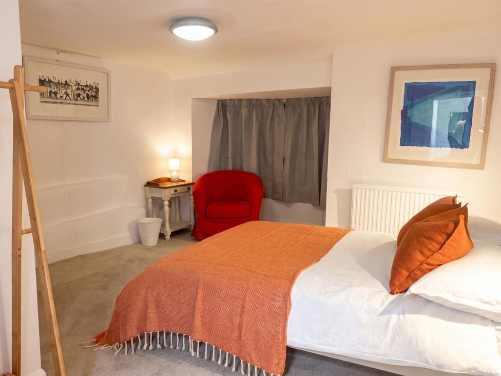 A bedroom with a bed and a red chair at The Old Barn in Manchester