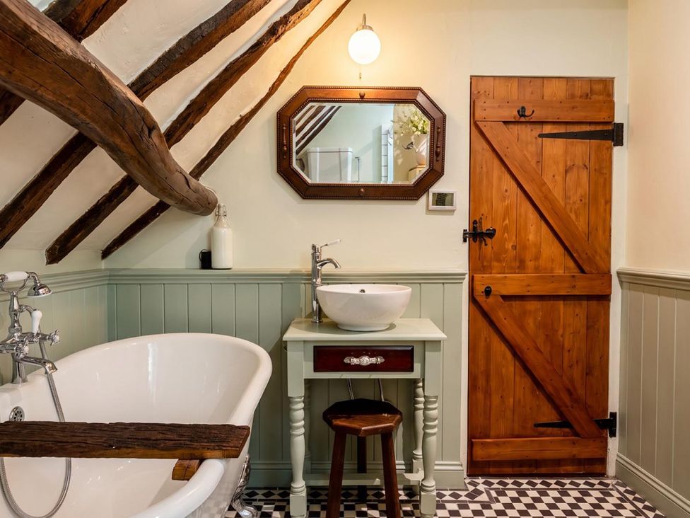 A bathroom with a bathtub, sink, and mirror at an unspecified location