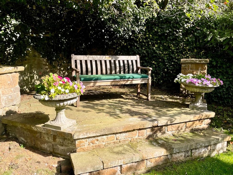 A bench with planters on either side at a garden