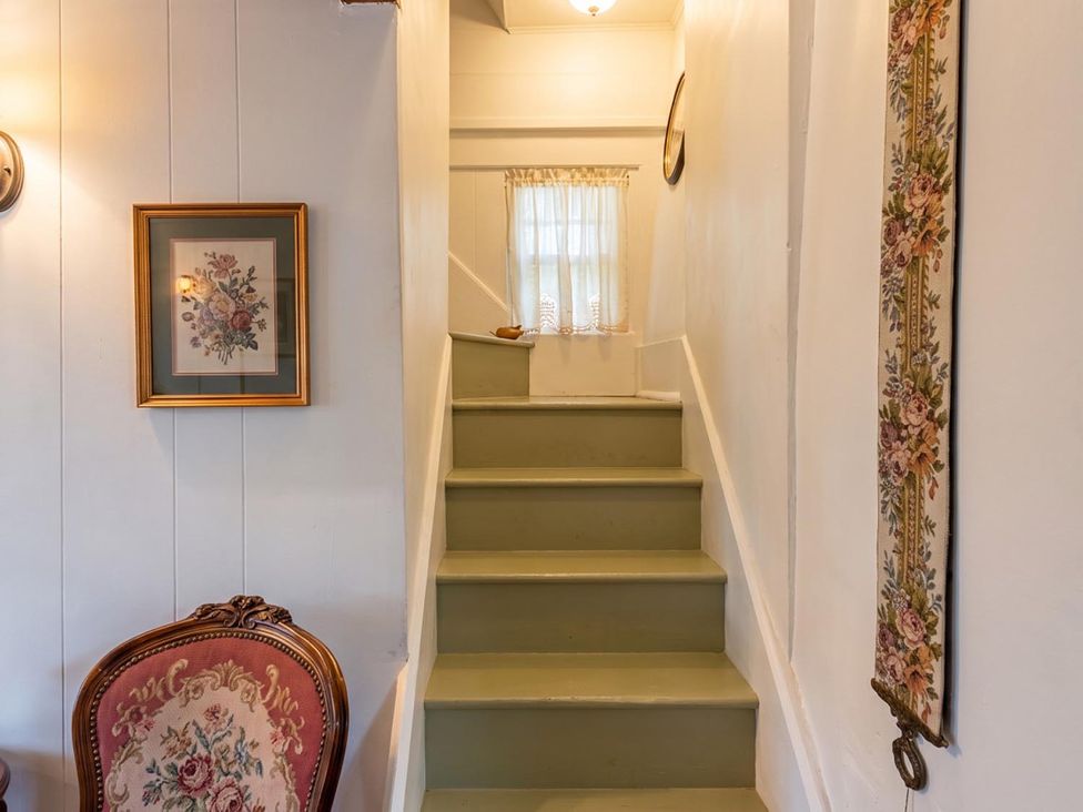 A staircase with wall decor and a chair at a property
