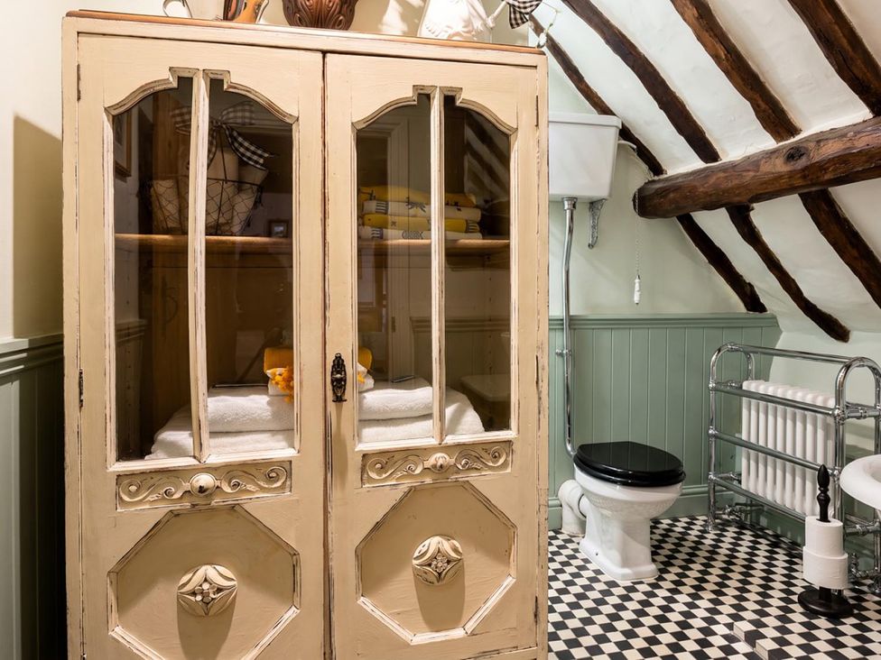 A bathroom with a cabinet and towels at The Old Barn in Manchester