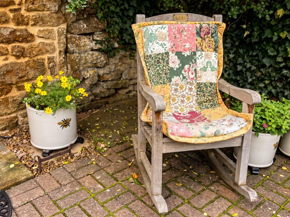 A rocking chair with a quilt on it in a garden at the property