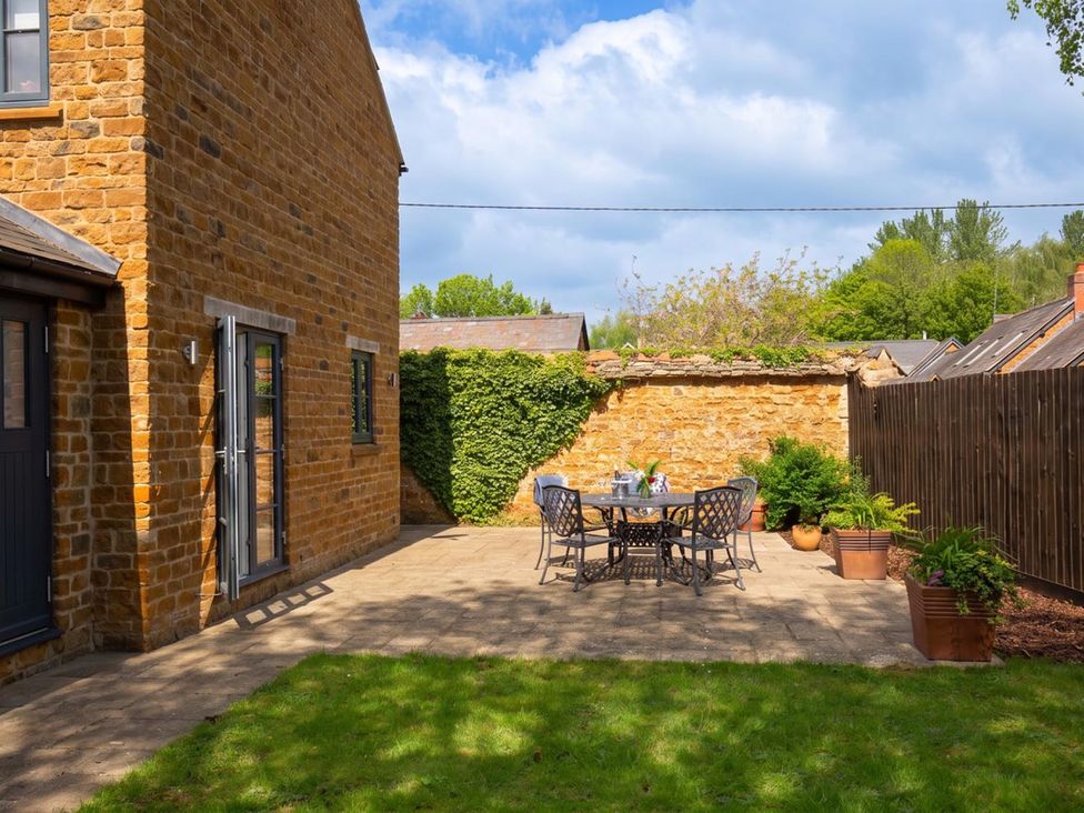 A garden with a stone wall and outdoor furniture at The Old Barn in Manchester