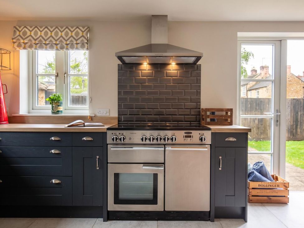 A kitchen with an oven, stove, cabinets, and window at the property in the unspecified location