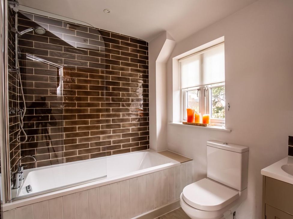 A bathroom featuring a bathtub, shower, toilet and window at the property in 