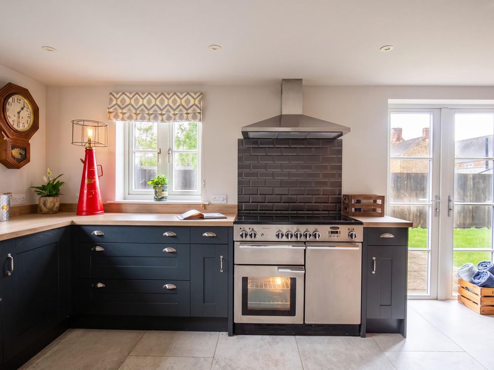 A kitchen with an oven, stove, and clock at 