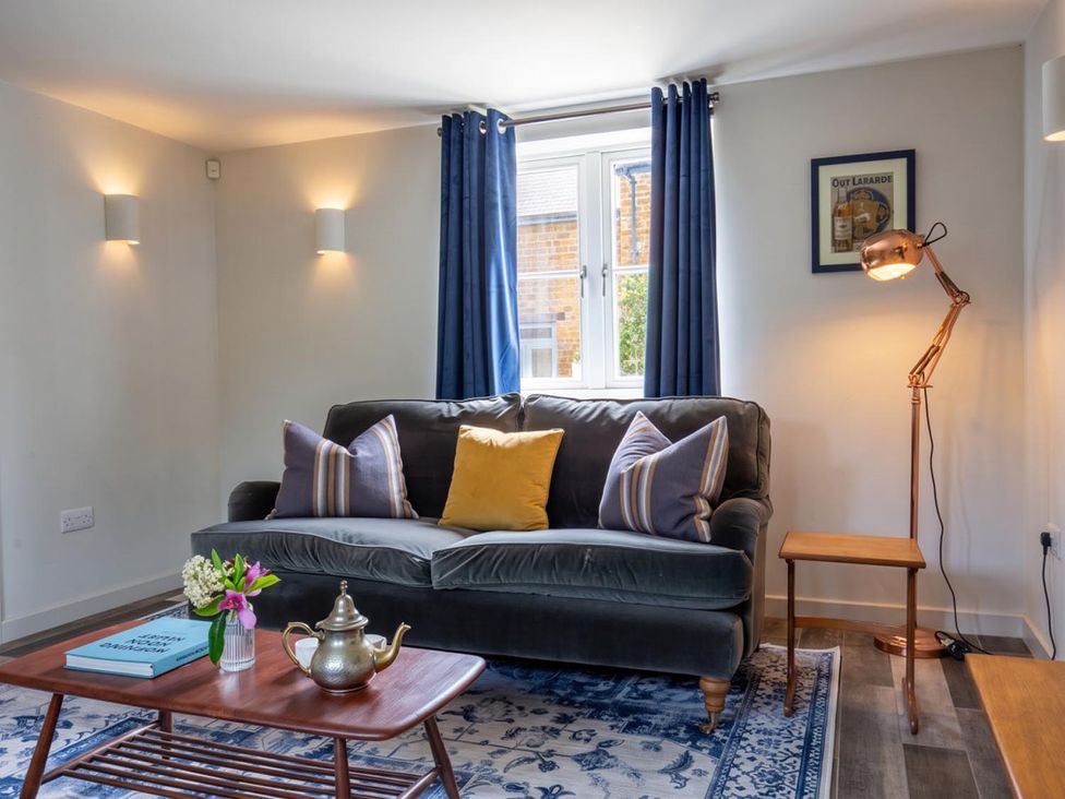 A living room with a couch, table, and lamp at The Old Barn in Manchester