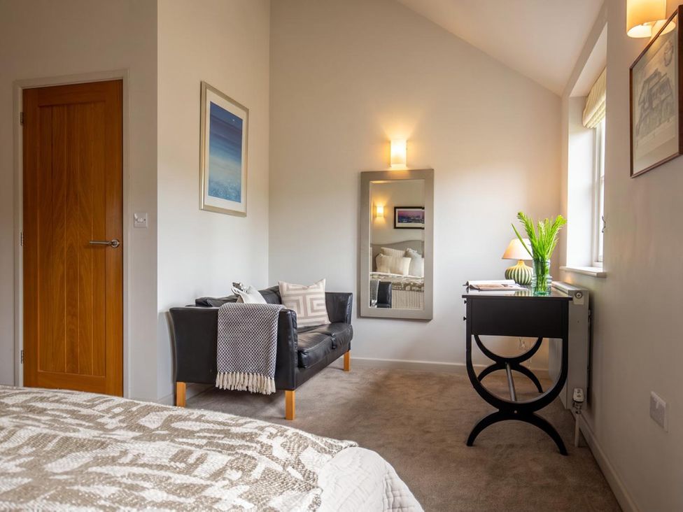 A bedroom with a sofa and a table at The Barn in Manchester