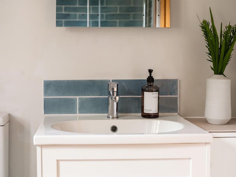 A sink with faucet and soap dispenser at a bathroom