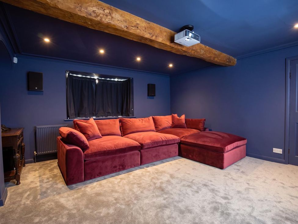 A home theater with a red sofa and projector at the property