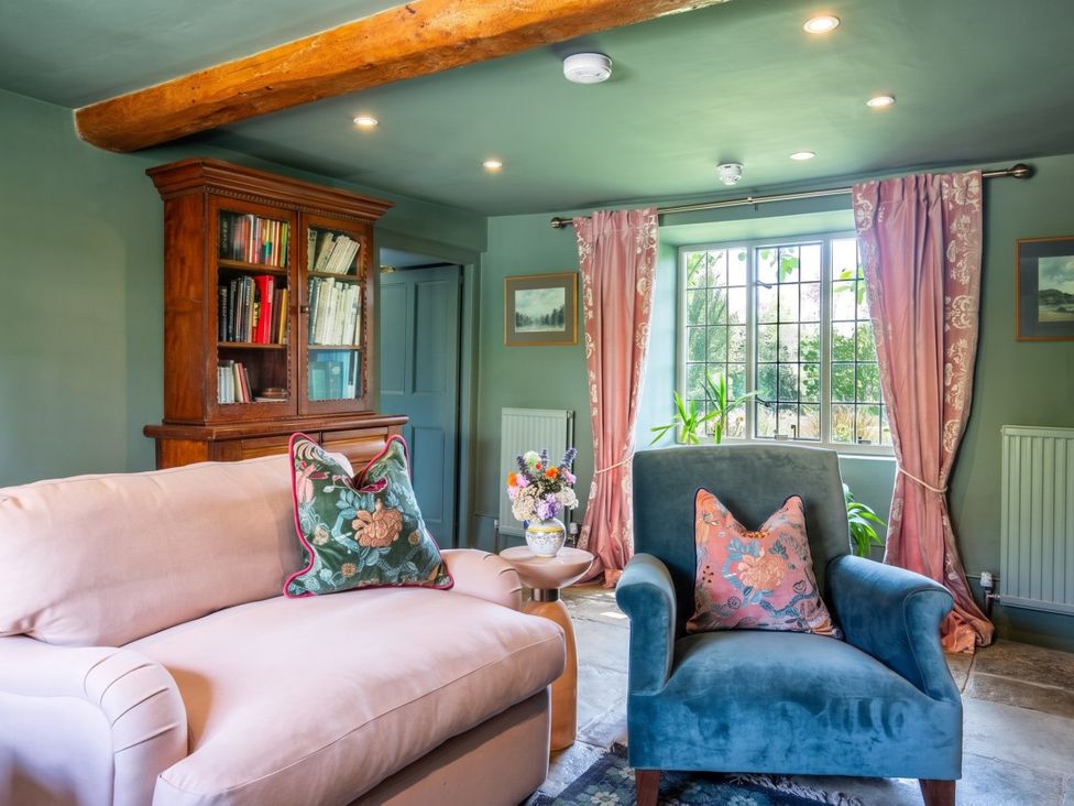 A living room with a sofa and armchair near a window at The Old Barn in Manchester