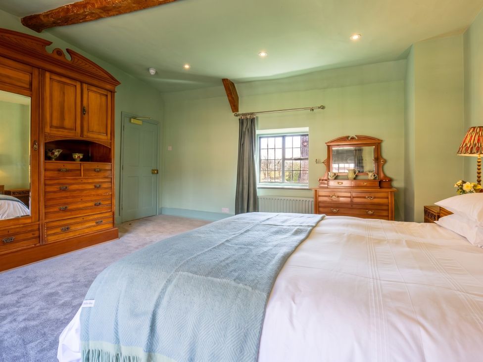 A bedroom with a bed and wooden furniture at The Old Barn in Manchester
