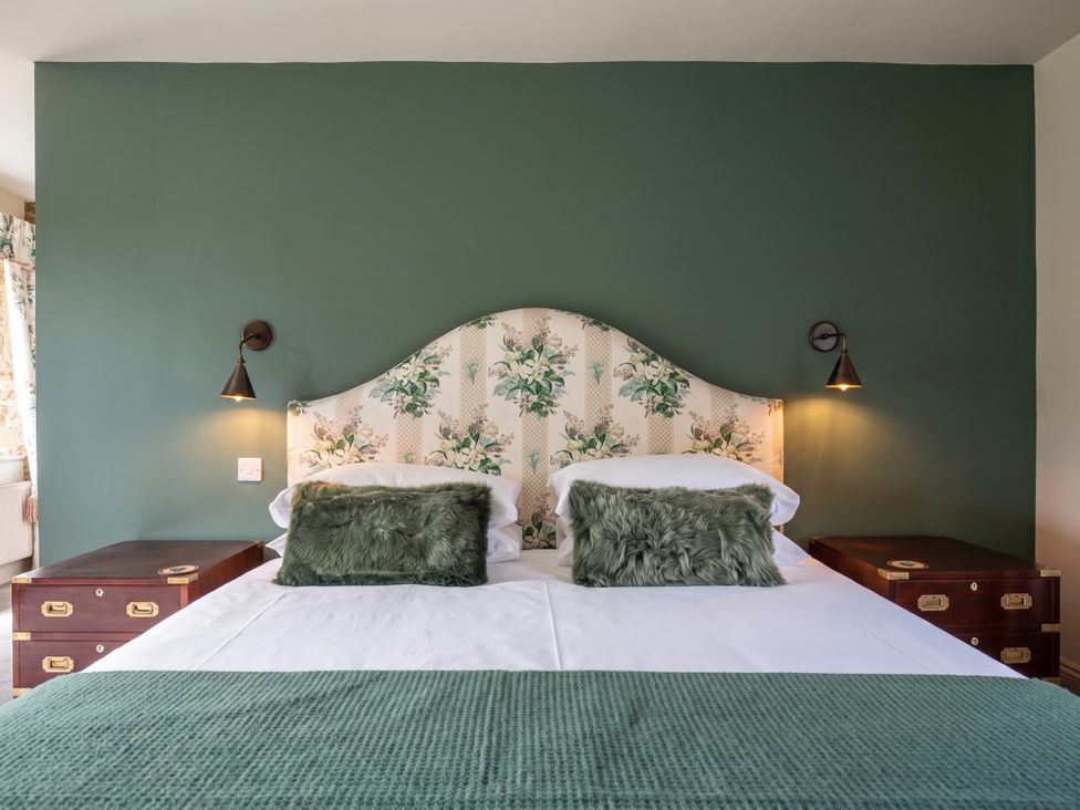 A bedroom with a bed and bedside tables at 