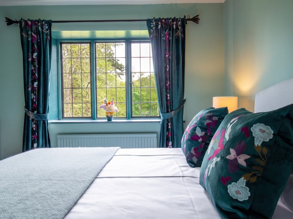 A bedroom with a window and floral decor at The Old Barn in Manchester