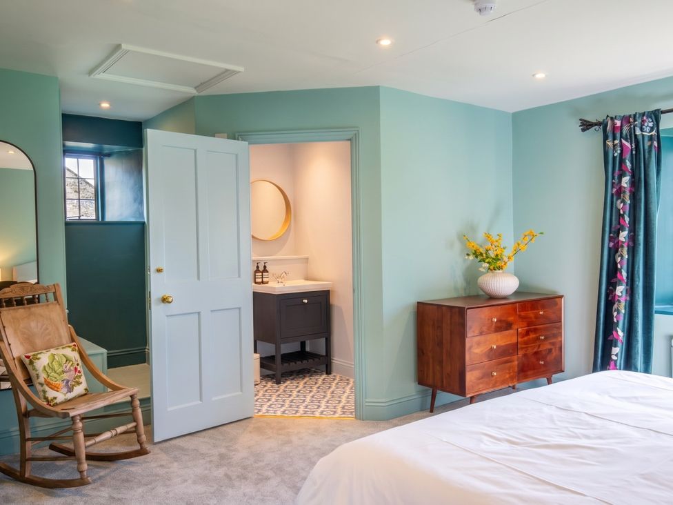 A bedroom with a door leading to a bathroom at The Old Barn in Manchester