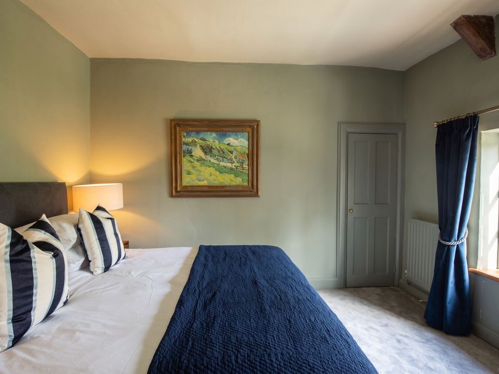 A bedroom with a bed and painting at an unspecified location