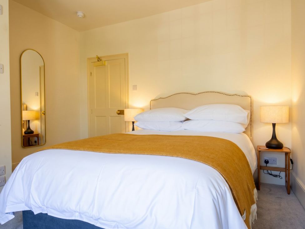 A bedroom with a bed and a mirror at The Old Barn in Manchester
