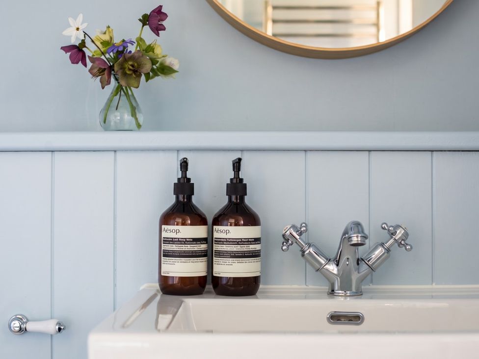 A bathroom sink with soap dispensers and flowers at an unspecified location