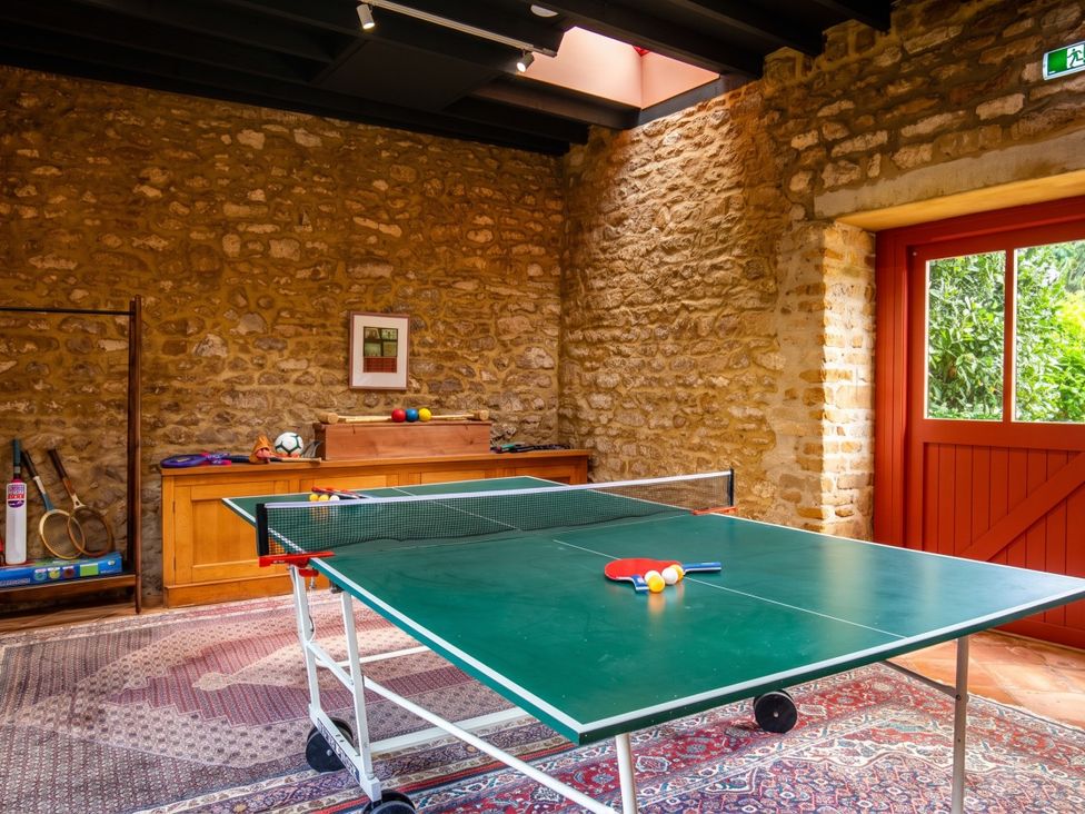 A games room with a table tennis table and wooden cabinet at The Old Barn in Manchester