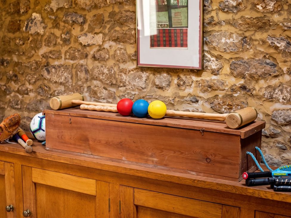 A wooden box with sports equipment on a wooden surface at The Old Barn in Manchester